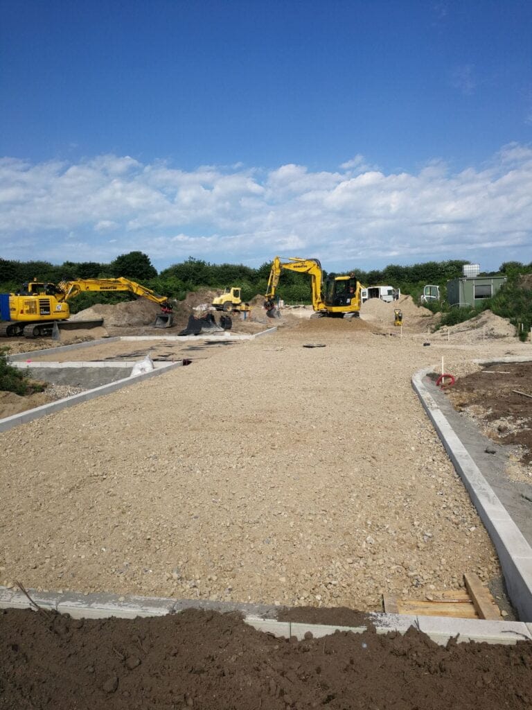 Vejbyggeri med gravemaskiner under klar himmel