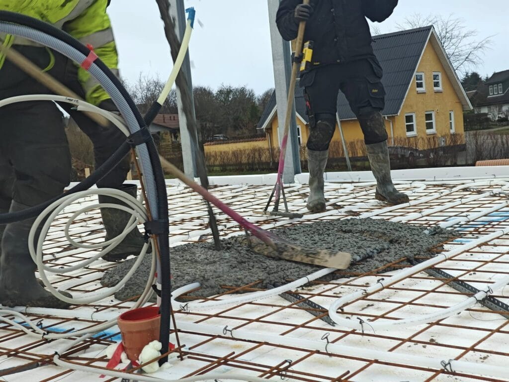 Arbejdere udjævner beton på husfundament